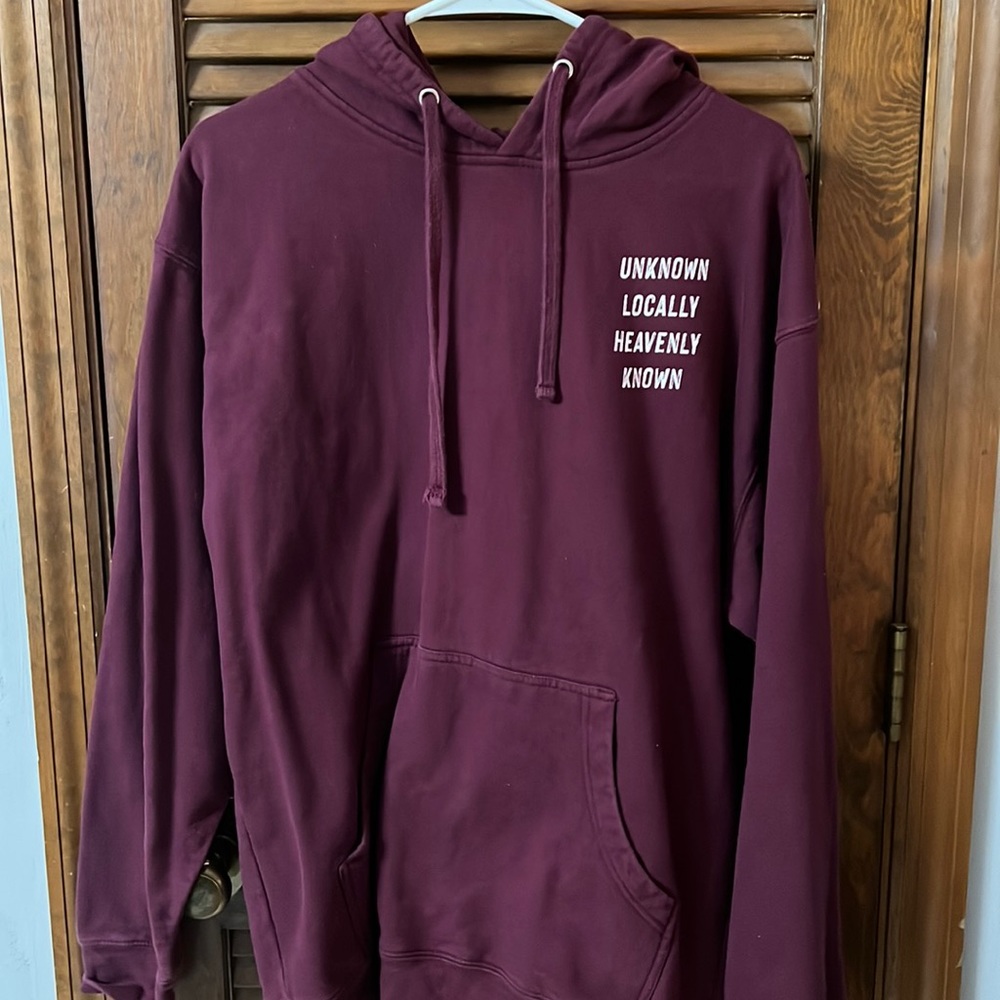 Unisex burgundy hoodie with great saying “unknown locally heavenly known “.